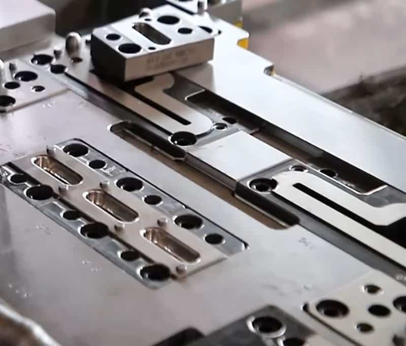 Close-up of precision injection mold components with slide mechanisms, guide pins, and cavity layout for high-volume production