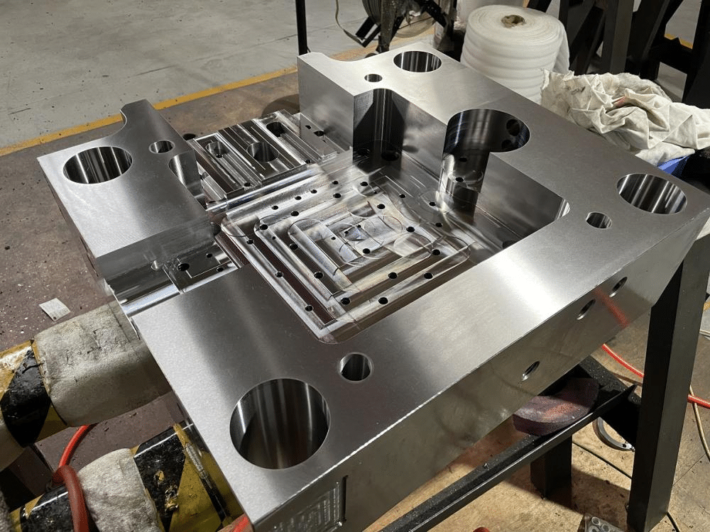 Precision injection mold base with CNC-machined cavities and cooling channels, where machining accuracy directly affects mold performance and failure risk