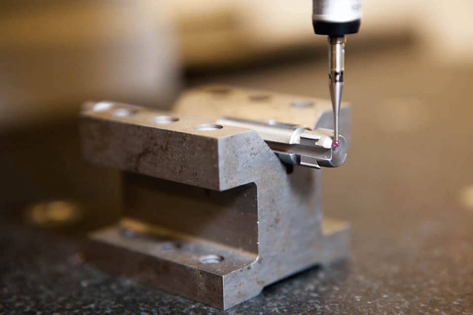 CMM probe inspecting a critical mold feature to verify tight tolerances and precise edge geometry