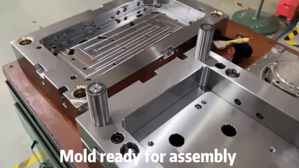 Injection mold ready for assembly, showing aligned mold plates, guide pillars, and precision-machined fitting surfaces