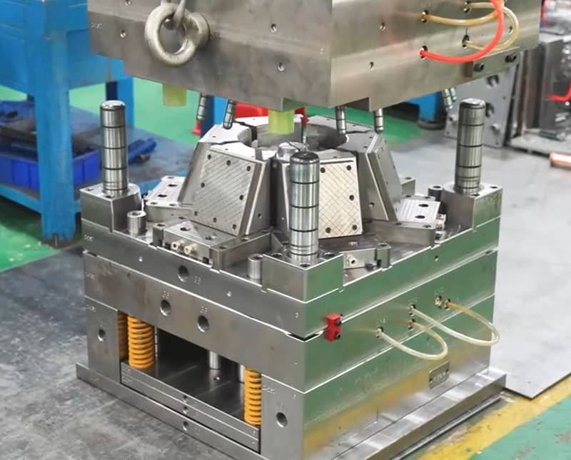 Complete multi-cavity injection mold with spring ejection system and integrated cooling lines for high-volume production